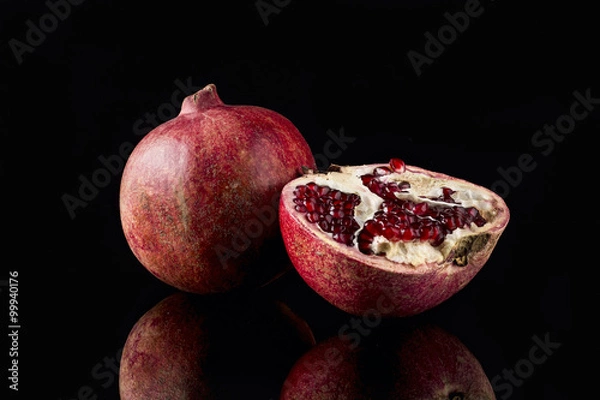 Obraz Ripe pomegranate on black background