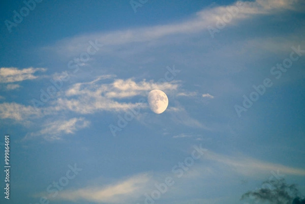 Fototapeta close up view of the moon during the day,full moon view of the moon on a blue and cloudy day