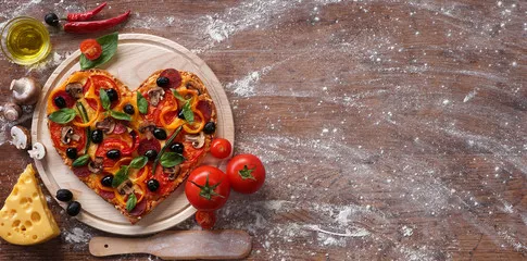 Fototapeta Kształt serca pizzy z składnikami i spazem kopiowania na tle vintage. Szczęśliwych walentynek. koncepcja miłości