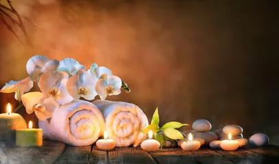 Fototapeta Spa - para ręczników ze świecami i orchideą do naturalnego masażu
