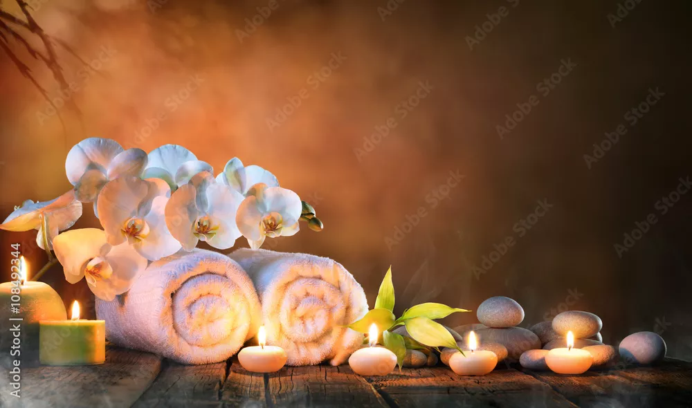Fototapeta Spa - para ręczników ze świecami i orchideą do naturalnego masażu
