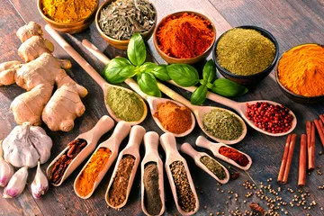 Fototapeta Różnorodność przypraw i ziół na stole kuchennym