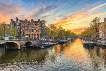 Fototapeta Amsterdam zmierzchu miasta linia horyzontu przy kanałowym nabrzeżem, Amsterdam, holandie