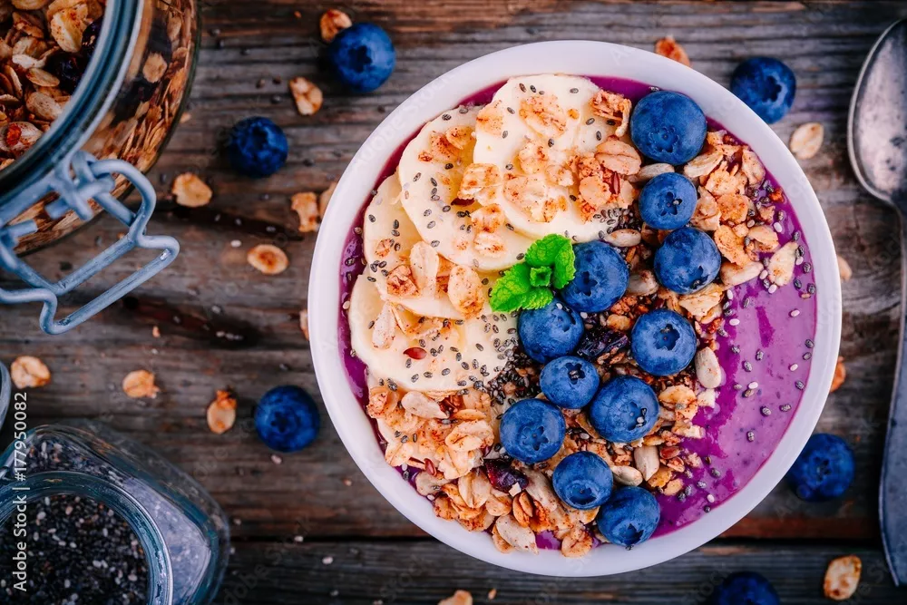 Fototapeta zdrowa miska smoothie z granolą, bananem i świeżymi jagodami