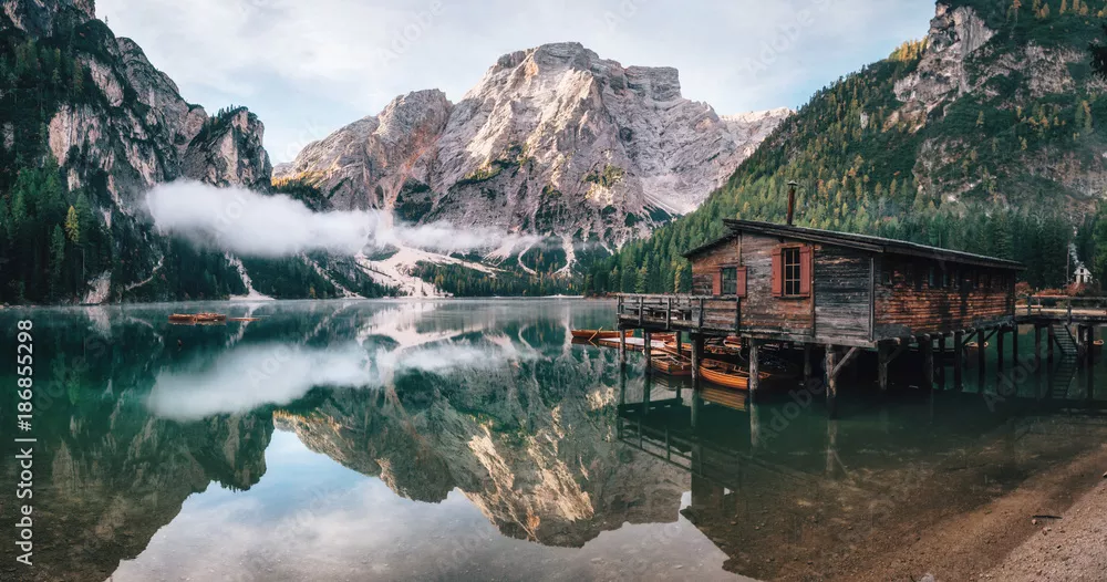 Fototapeta Panoramiczny widok na jezioro Braies z chatą i łodziami w Dolomitach i Seekofel o poranku, Sudtirol, Włochy