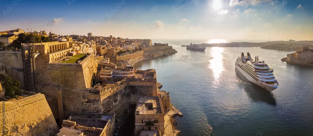 Fototapeta Valletta, Malta - panoramiczny widok z lotu ptaka na Vallettę, gdy statki wycieczkowe pływają w porcie Grand o wschodzie słońca