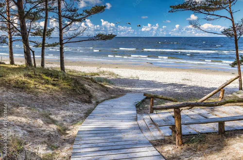 Fototapeta Malowniczy widok i drewniane miejsce do odpoczynku w pobliżu piaszczystej plaży Morza Bałtyckiego