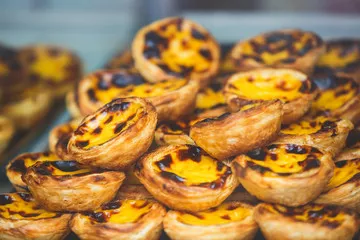 Fototapeta Tradycyjne portugalskie jajka tartowe ciasta, deser pasteis de nata z różnym portugalskim ciasta w oknie kawiarni, pastel de nata
