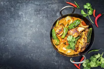 Fototapeta Tradycyjne tajskie kaeng massaman kokosowe curry z kurczaka z jalapeno, poblano chili i słodkimi ziemniakami jako zbliżenie w tradycyjnej misce z pozostawionym miejscem na kopię