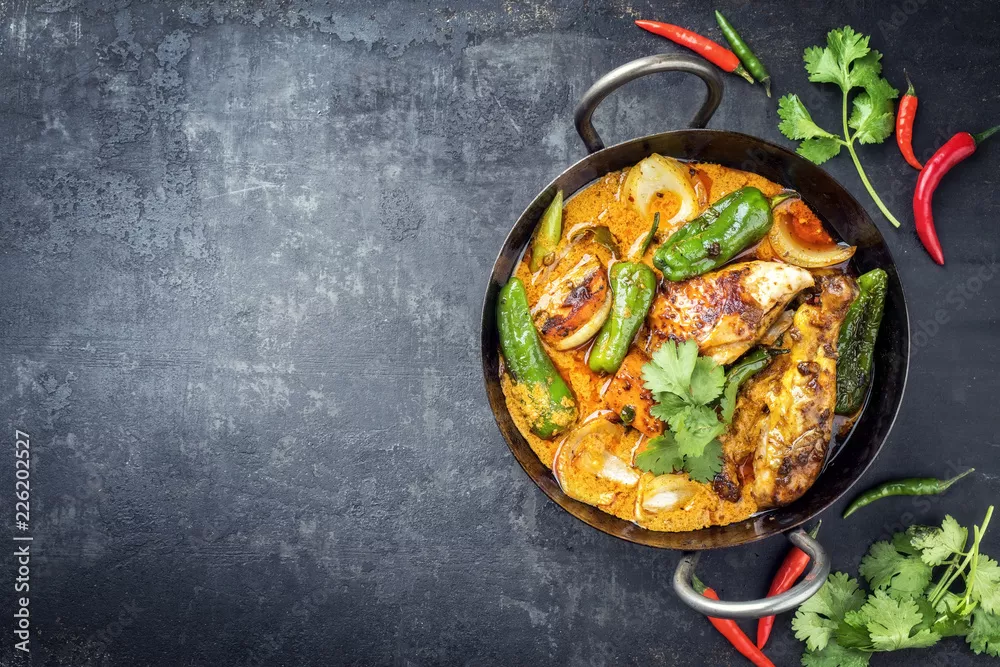 Fototapeta Tradycyjne tajskie kaeng massaman kokosowe curry z kurczaka z jalapeno, poblano chili i słodkimi ziemniakami jako zbliżenie w tradycyjnej misce z pozostawionym miejscem na kopię