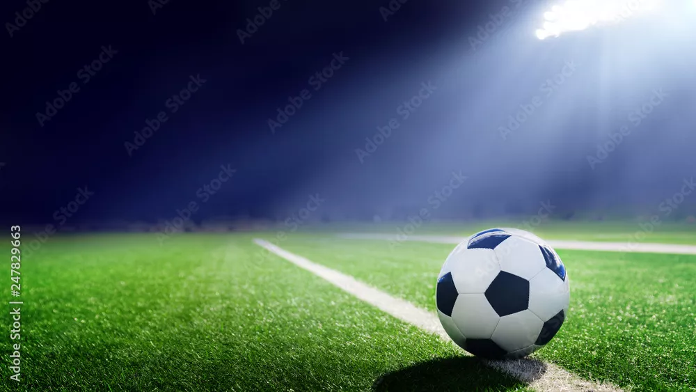 Fototapeta Tradycyjna piłka nożna oświetlona światłami stadionu