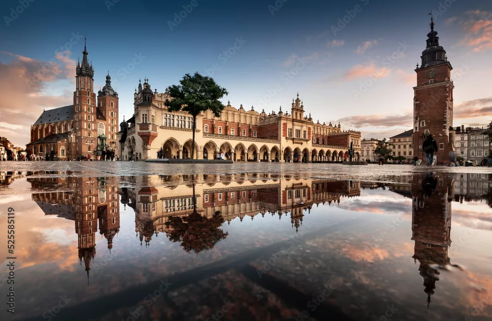 Obraz rynek główny w krakowie z widokiem na sukiennice, bazylikę mariacką w naturalnym lustrze.