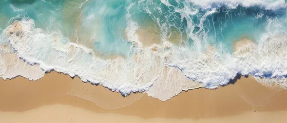 Fototapeta Przypływ spienionych fal morskich na piaszczystej złotej plaży w widoku z lotu ptaka