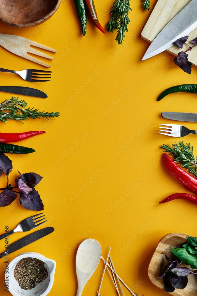 Fototapeta Bezpośrednio nad żółtym stołem udekorowanym sztućcami, papryczką chili i ziołami