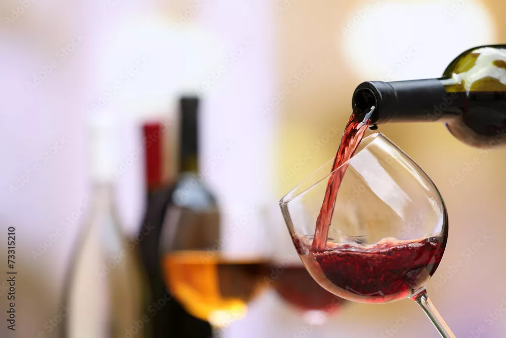 Fototapeta Czerwone wino wlewając do kieliszka do wina, zbliżenie
