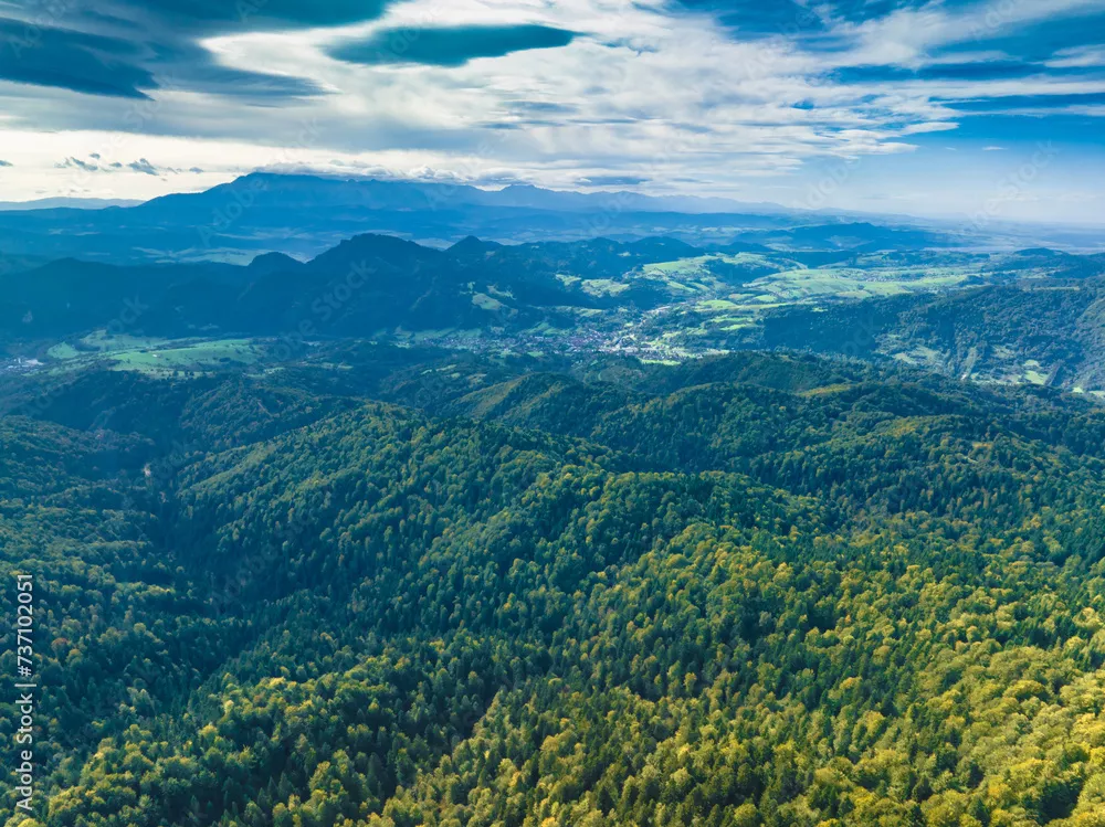 Obraz panoramiczny widok na górską krainę – warstwowe wzgórza i soczyście zielone lasy