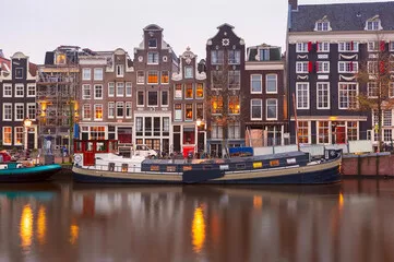 Fototapeta Amsterdamski kanał Singel z typowymi holenderskimi domami podczas porannej niebieskiej godziny, Holandia, Holandia.
