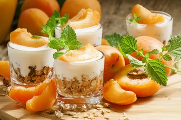 Fototapeta Domowa muesli z jogurtem i morelem w szklanych miskach, zdrowe