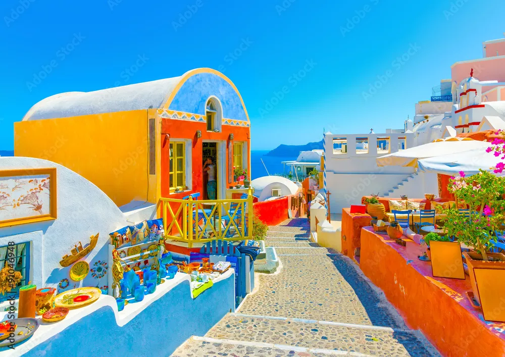 Fototapeta Typowa kolorowa wąska uliczka w Oia, najpiękniejszej miejscowości na wyspie Santorini w Grecji